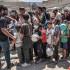 Hombres, mujeres y niÃ±os hacen cola para recibir raciones de comida en una cocina pÃºblica de Deir el-Balah, en el centro de Gaza.