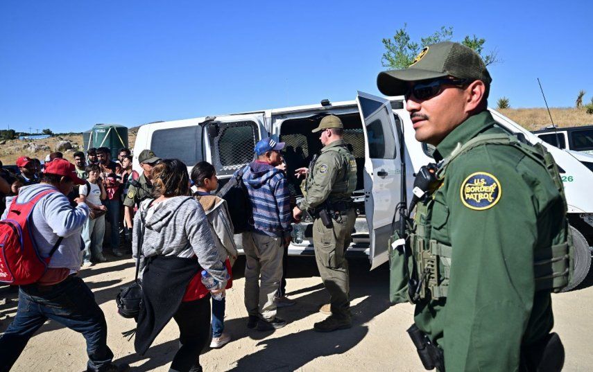 Agentes de Aduanas y Patrulla Fronteriza suben a migrantes a un vehículo después de que ingresaron en grupos a Estados Unidos desde México en Jacumba Hot Springs, California, el 5 de junio de 2024.